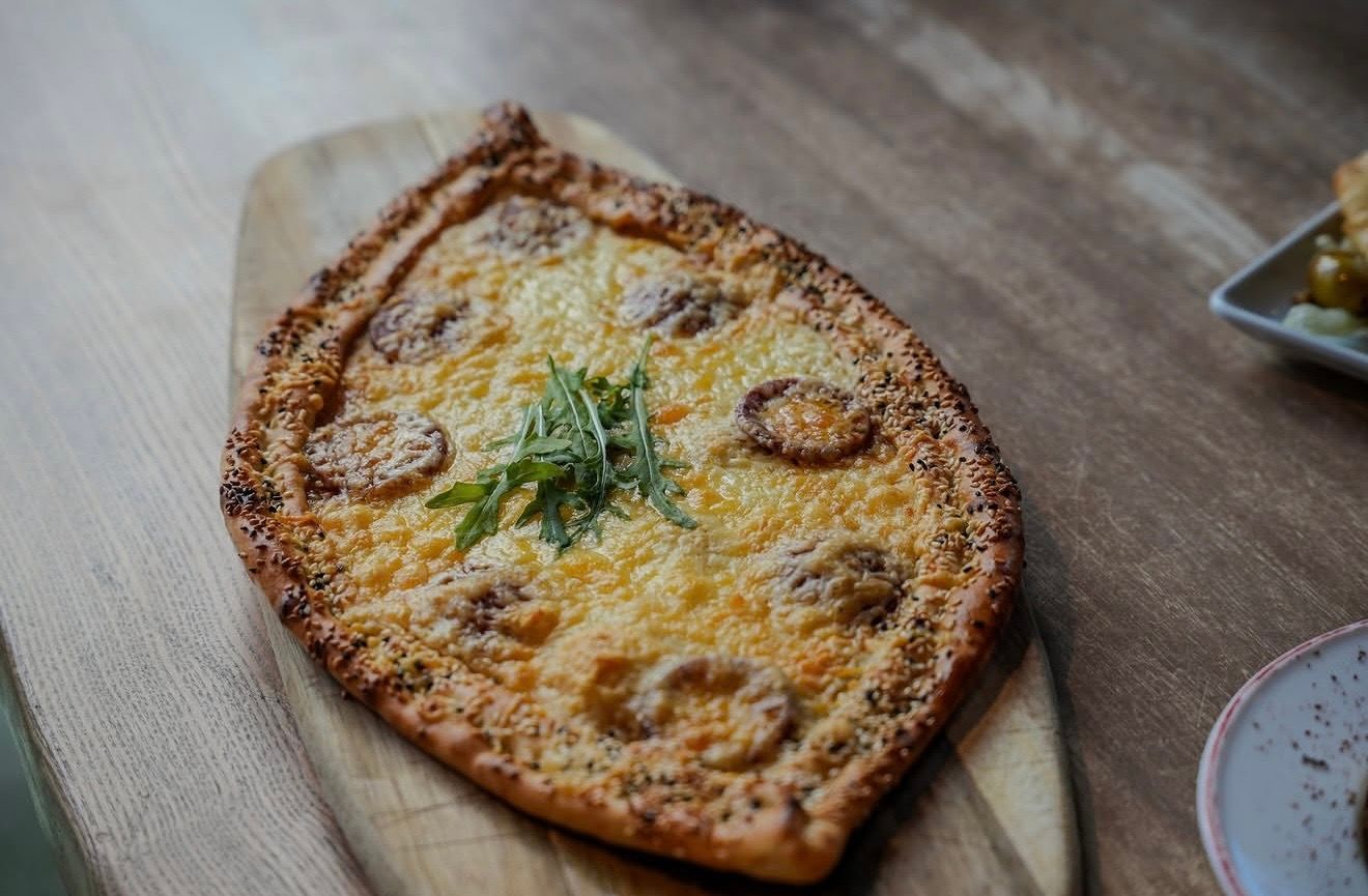 Frisch gebackene Pide mit Käse auf einem Holzbrett